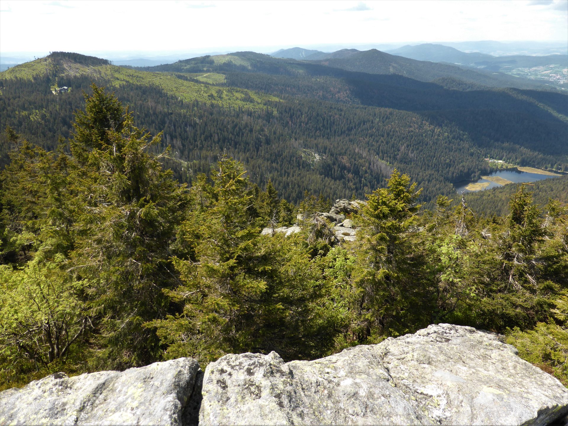 Großer Arber im Bayerischen Wald: Blick vom Gipfel über Bergwald und Felsen ins Tal mit dem Kleinen Arbersee